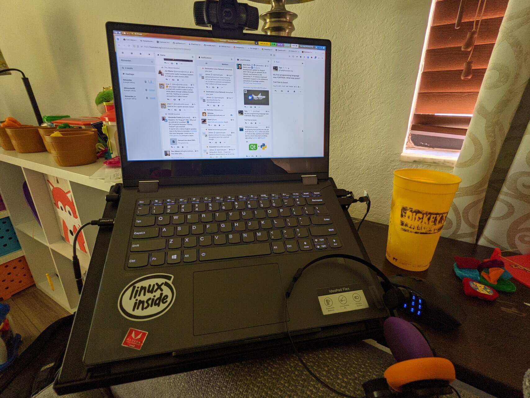 Laptop with webcam, mouse, and headphones on a stand